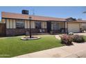 Inviting single-story home with a well-kept lawn and landscaped front yard with charming brick accents at 5347 W Seldon Ln, Glendale, AZ 85302