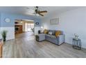 Bright living room featuring modern wood-look floors and cozy gray sectional at 5347 W Seldon Ln, Glendale, AZ 85302