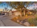 Charming two-story home with a tile roof, attached garage, and a desert-landscaped front yard with rock and cactus at 6841 S Roosevelt St, Tempe, AZ 85283