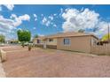 Side view of a single-story home with a gravel yard and wooden fence, under a partly cloudy sky at 8602 N 27Th Ave, Phoenix, AZ 85051