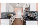 Modern kitchen with sleek black countertops, white cabinets, and stainless steel appliances at 8602 N 27Th Ave, Phoenix, AZ 85051