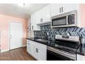 Bright kitchen featuring stainless steel appliances, stylish backsplash, and ample cabinet space at 8602 N 27Th Ave, Phoenix, AZ 85051