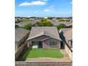 Aerial view of a home's backyard featuring green grass, desert landscaping, block wall fence and nearby stadium at 9147 W Minnezona Ave, Phoenix, AZ 85037