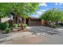 Charming single-story home with a stone facade, well-manicured landscaping, and a two-car garage at 9147 W Minnezona Ave, Phoenix, AZ 85037