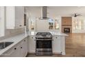 Bright, spacious kitchen featuring white cabinets, stainless steel appliances, and island with cooktop at 942 S Ash Ave # 104, Tempe, AZ 85281
