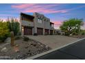 Southwestern style home showcasing a spacious three-car garage, neutral colors, and desert landscaping at 11398 E Desert Vista Rd, Scottsdale, AZ 85255