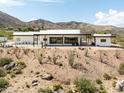 Contemporary home with a flat roof, desert landscaping and mountain views at 11426 E Quail Ln, Cave Creek, AZ 85331