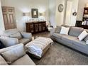 Comfortable living room with neutral-toned furniture, a decorative cabinet, and ample seating at 12027 W Morning Dove Dr, Sun City, AZ 85373