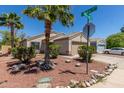 Well-kept single-story home with desert landscaping, mature trees, and a two-car garage at 12438 W Flores Dr, El Mirage, AZ 85335