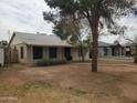 Inviting single-story home with a well-kept lawn and mature trees creating a serene setting at 1363 E Clarendon Ave, Phoenix, AZ 85014