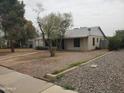 Cozy home featuring desert landscaping, mature trees, and a charming single-story design at 1363 E Clarendon Ave, Phoenix, AZ 85014