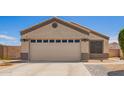 Single story home with a two car garage, desert landscaping, and a driveway with paved walkway at 14809 N El Frio Cir, El Mirage, AZ 85335