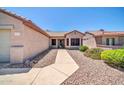 Inviting front entrance with desert landscaping along a walkway leading to a tan home at 15161 W Cactus Ridge Way, Surprise, AZ 85374
