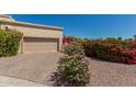 Paved driveway leading to a neutral-colored garage, complemented by colorful desert landscaping at 16734 E Gunsight Dr # 109, Fountain Hills, AZ 85268