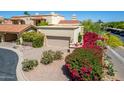 Inviting exterior with tile roof, desert landscaping, and a tan garage door on a sunny day at 16734 E Gunsight Dr # 109, Fountain Hills, AZ 85268