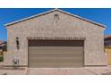 View of the home's garage featuring tan stucco and a paver driveway at 1824 N Red Clf, Mesa, AZ 85207