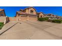 Wide driveway leading to a tan home with a two car garage and desert landscaping at 1902 S Rialto -- # Mesa, Mesa, AZ 85209
