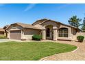 Well-maintained single-story home with green lawn, desert landscaping, and a two-car garage at 2244 E Rawhide St, Gilbert, AZ 85296