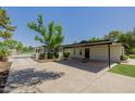 Long driveway with carport and a glimpse of the tennis court and the garage at 2350 E Melrose St, Gilbert, AZ 85297