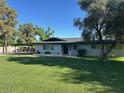 Inviting one-story home with a covered parking area and a verdant front yard under a bright sky at 2350 E Melrose St, Gilbert, AZ 85297