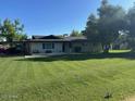 Attractive one-story home with well-manicured lawn and a covered carport, shaded by mature trees at 2350 E Melrose St, Gilbert, AZ 85297
