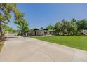 Wide view of property showing the main house, garage, driveway and manicured lawn at 2350 E Melrose St, Gilbert, AZ 85297