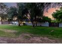 Single-story home features a lush green lawn with mature trees in the front yard, offering shade and curb appeal at 2350 E Melrose St, Gilbert, AZ 85297
