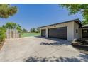 Spacious three car garage with dark doors and lights outside with tennis court in the back at 2350 E Melrose St, Gilbert, AZ 85297