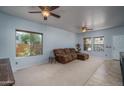 Cozy living room with neutral carpet, ceiling fans, and natural light at 26062 W Potter Dr, Buckeye, AZ 85396