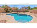 Inviting backyard pool area with a charming rock feature and desert landscaping at 30032 N Desert Willow Blvd, San Tan Valley, AZ 85143