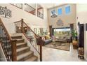 Open-concept living room with soaring ceilings, staircase, and ample natural light at 31156 N 137Th Ln, Peoria, AZ 85383