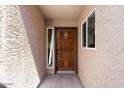Inviting front entrance featuring a stained wood door with sidelight and stylish exterior texture at 3345 E University Dr # 72, Mesa, AZ 85213