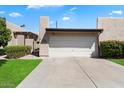 Attached two-car garage with a well-maintained desert landscape and green grass in front at 3345 E University Dr # 72, Mesa, AZ 85213