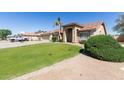 Well-manicured front lawn of this home with mature landscaping and an arched entryway at 3784 E Simpson Ct, Gilbert, AZ 85297