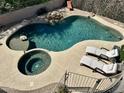 Aerial view of a backyard pool with a unique rock waterfall, a hot tub, and lounge chairs at 3812 N Barron --, Mesa, AZ 85207