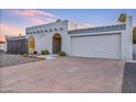 Inviting single-story home with stucco walls, arched entryway, and a spacious two-car garage at 6739 E Thunderbird Rd, Scottsdale, AZ 85254