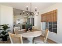 Cozy dining area features a round table with unique chandelier and a window at 9143 W Kings Ave, Peoria, AZ 85382