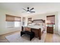 Serene primary bedroom with wooden furniture, plush bedding, and three windows offering natural light at 9143 W Kings Ave, Peoria, AZ 85382