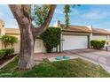 Charming home featuring a lush yard, and a well-maintained two-car garage with a brick-paved driveway at 106 E Echo Ln, Phoenix, AZ 85020