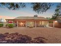 Expansive backyard showcasing covered patio, dining set, lounge chair, and mature landscaping with privacy bushes at 10937 N Ventana W Dr, Peoria, AZ 85373