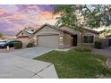 Welcoming single-story home with a two-car garage, attractive landscaping, and a well-maintained lawn at 13723 W Rovey Ave, Litchfield Park, AZ 85340
