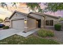 Attractive single-story home featuring a two-car garage, desert landscaping, and a inviting entrance at 13723 W Rovey Ave, Litchfield Park, AZ 85340
