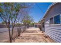 The home features a simple yard with chainlink fence and trees lining the side at 1410 S 24Th Ave, Phoenix, AZ 85009