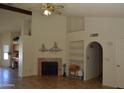 Cozy living room featuring a fireplace, tile floors, and archway to the hallway at 14626 N 40Th Way, Phoenix, AZ 85032