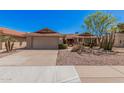 Attractive single-story home featuring desert landscaping, mature trees, and a two-car garage at 1473 Leisure World --, Mesa, AZ 85206