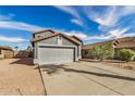 A view of a single-story home featuring desert landscaping, a two-car garage, and a tile roof at 15339 N 148Th Ct, Surprise, AZ 85379