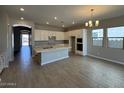 Spacious kitchen with white cabinetry, an island, and modern lighting at 15642 W Georgia Dr, Surprise, AZ 85379