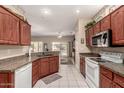 Bright kitchen featuring wood cabinets, granite countertops, a white stove, and views of the outdoor patio at 16240 W Talara Way, Surprise, AZ 85374