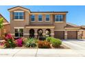 Two-story home features a three-car garage, arched entryway, and desert landscaping at 16245 W Papago St, Goodyear, AZ 85338