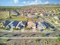 An aerial view shows homes in a large neighborhood with desert landscaping and blue sky with some clouds at 18381 W La Senda Dr, Surprise, AZ 85387